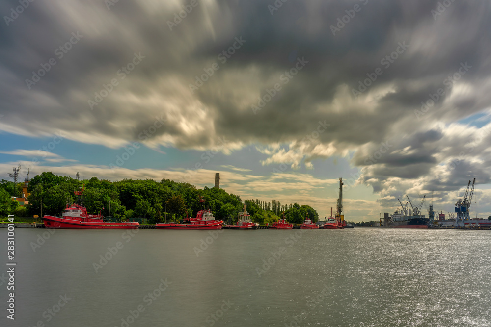 Fototapeta premium Port of Gdansk, Poland. Tugboats are awaiting the waterfront, in the depths of the Westerplatte monument