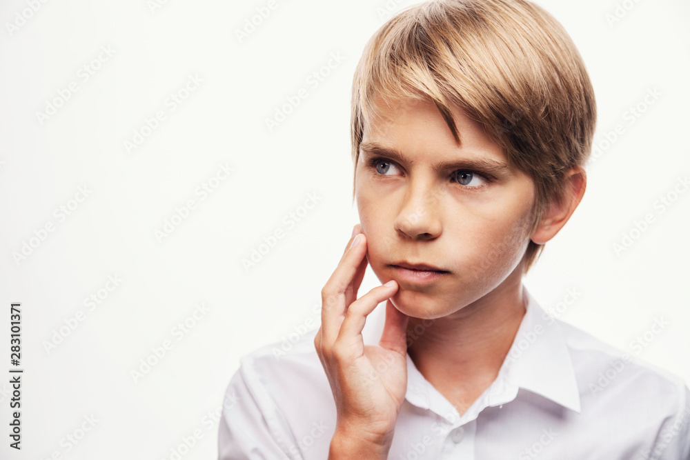 Blond boy thinking with his hand rubbing his cheek and chin Blond boy thinking with his hand rubbing his cheek and chin