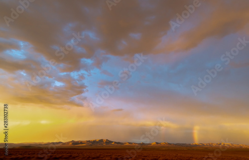 USA, Nevada, Lyon County. Strong blue-orange contrast trope as well as a bit of a rainbow in this classic western sunset scene over Painted Mesa. photo