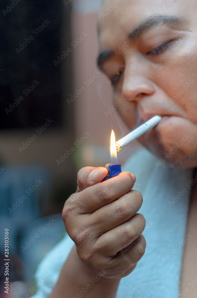 Fototapeta premium Man lighting up cigarette