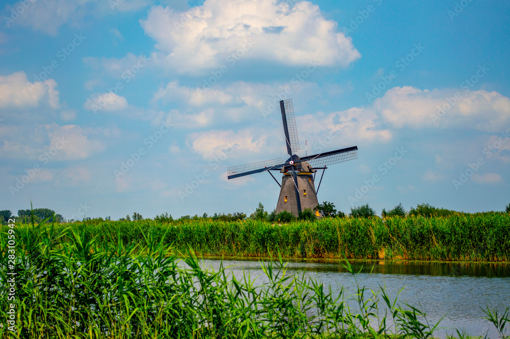 Netherlands rural picturesque scene with traditional Dutch windmill near the canal in Kinderdijk, Holland.