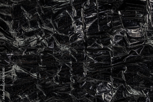 black polyethilene film enforced by sticky tape flat smuggle package closeup texture