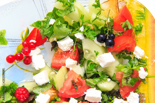 Fresh summer salad with soft feta cheese and some berries.