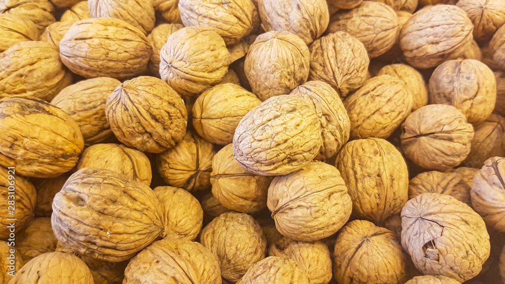 lots of brown inshell walnuts texture at the fresh vegan market