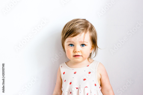 Serious thoughtful attentive child toddler girl against white background