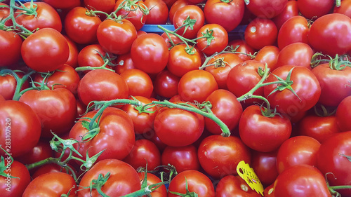 little red fresh ripe tomatoes background at the fruit market stand