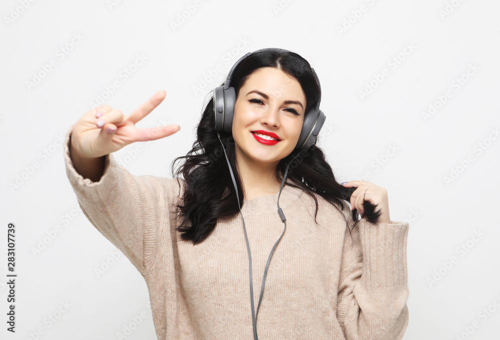  woman looking at camera with smile and showing peace sign with fingers