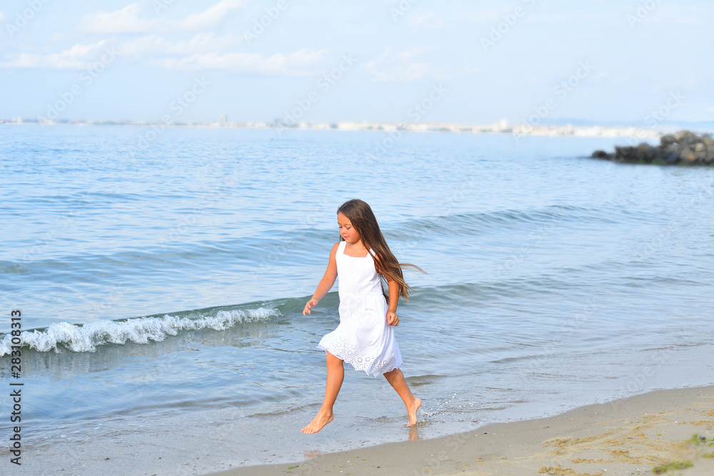 barefoot girl runs on the sand on the beach.Summer marine weekend barefoot girl runs on the sand on the beach.Summer marine weekend