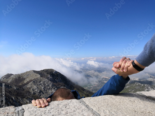 Man gives a helping hand falling from a cliff man.