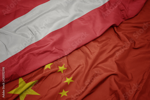 waving colorful flag of china and national flag of austria.