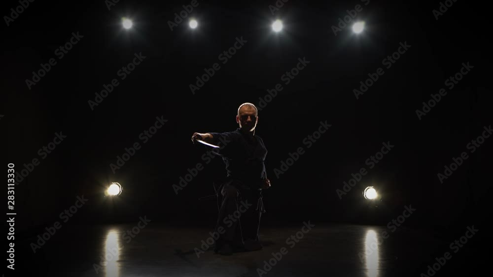 Masculine Kendo fighter practicing martial art with the Katana sword. Masculine Kendo fighter practicing martial art with the Katana sword.