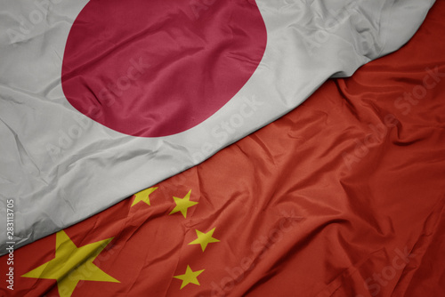 Fototapeta waving colorful flag of china and national flag of japan.