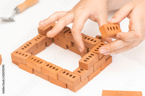Construction of small brick blocks, toy for child development on white background.