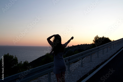 Silhouette of woman standing near the road