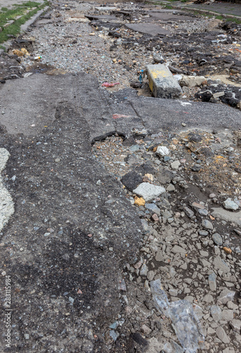 Large cracks, chips. Broken asphalt shifted landslide after flood. Destroyed road by water. Groundwater flushing. Concept of destruction of roads from nature. Consequences of flood. Broken  street
