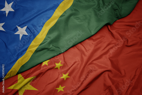 waving colorful flag of china and national flag of Solomon Islands.