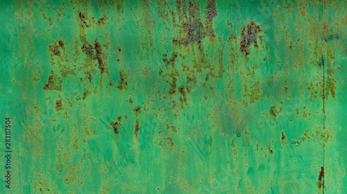 Peeling green paint on old wall background texture.