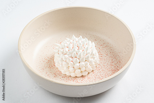 meringue with mango sauce on the white plate