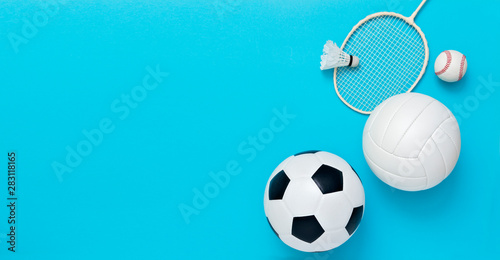 Fototapeta Naklejka Na Ścianę i Meble -  Assorted sports equipment including a basketball, soccer ball, volleyball, baseball, badminton racket on a light blue background