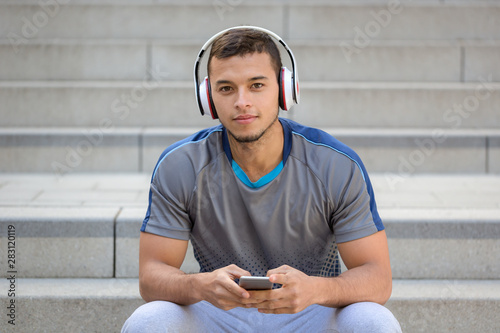 Listening to music young latin man with headphones listen smartphone smart phone