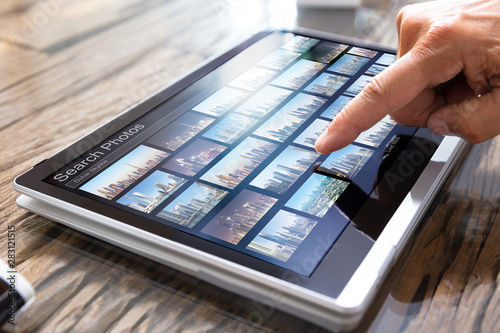 Editor Searching Photos On Tablet photo