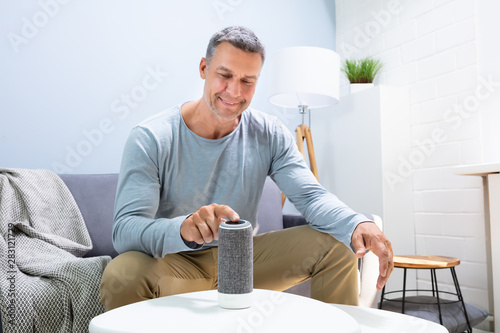 Man Pressing Button On Wireless Speaker photo