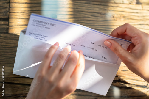 Businessperson Opening Envelope With Paycheck photo