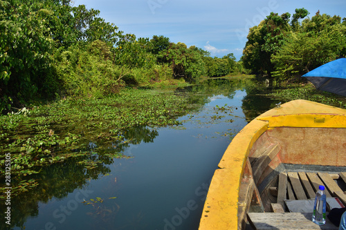 A boat tour in Buxa Tiger Reserve in West Bengal, India. A ride through the jungle. Front of the boat visible to the right. Himalaya mountains in front visible. photo