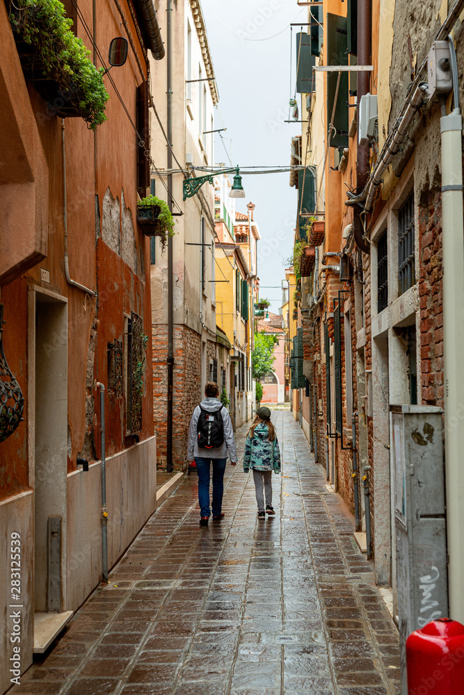Woman and girl waling on a narrow street in Venice