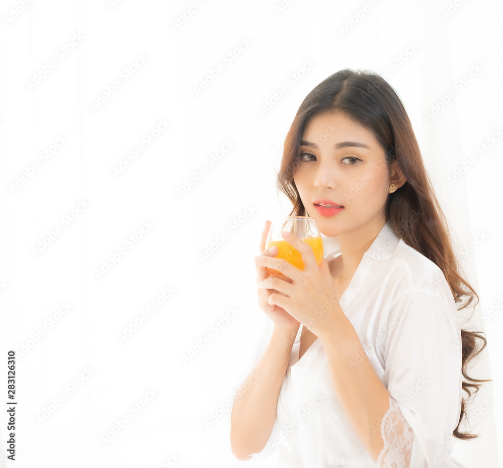Portrait of a cute woman with brunet hair wearing white dress isolated over white background , drinking orange juice cocktail from a glass. Portrait of a cute woman with brunet hair wearing white dress isolated over white background , drinking orange juice cocktail from a glass.