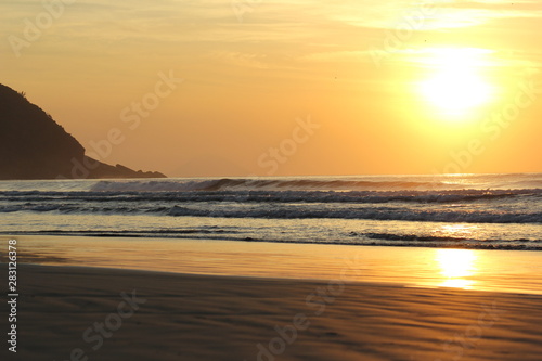 The sun rising at Sao Lourenco beach, Bertioga, Brazil on a summer day 