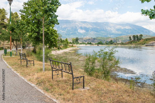 Empty wooden park bench overlooking Viroi lake.