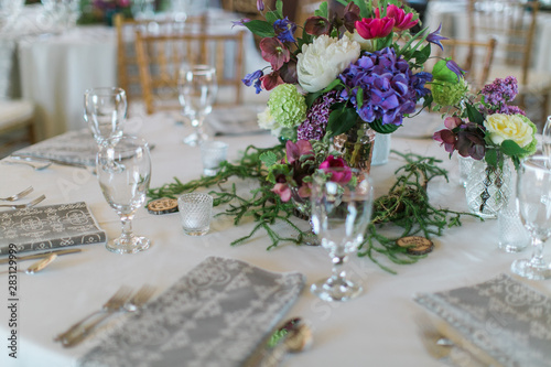 Colorful wedding arrangements on table, white peonies, blue and hot pink flowers, reception decor, bohemian table flowers