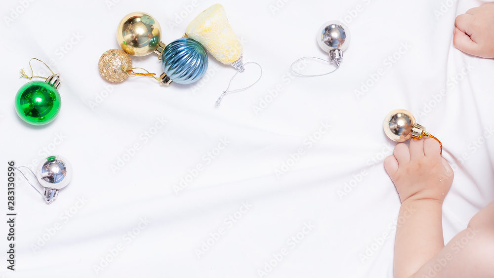 Baby boy playing with christmas balls and toys