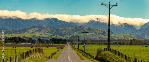 Rural road from the Eastern hills to the cloud covered Tararua ranges in Wairarapa New Zealand