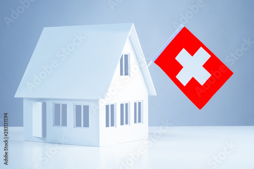 Immigration abroad. Miniature house with the flag of Switzerland. To leave for permanent residence to Switzerland. Resettlement to Switzerland. Accommodation in Europe. Emigration.