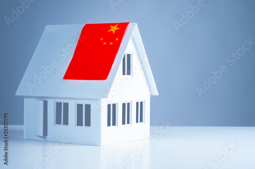 The flag of China on the layout of the cottage with white walls. Republic of China. Accommodation in Beijing. Acquisition of real estate in China. Immigration.