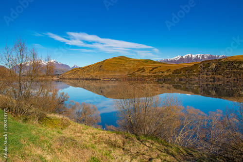 Lake Hayes on a clear blue sky, beautiful water reflection, Frankton, Lake Hayes New zealand