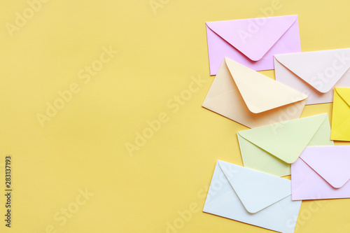 Colorful envelopes on yellow background photo
