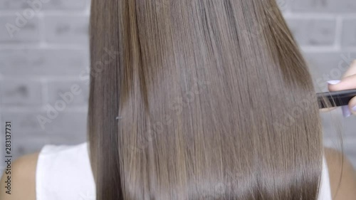 Result after lamination and hair straightening in a beauty salon for a girl with brown hair. hair care concept