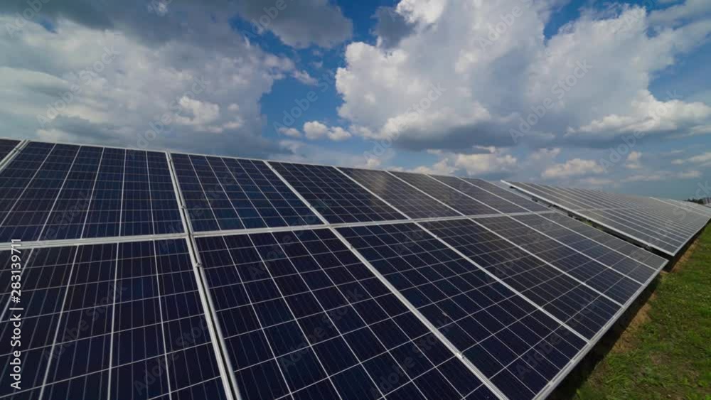 Power station. Solar panels under the blue sky with white clouds. Alternative source of electricity on solar energy farm. Source of ecological renewable energy. Power station. Solar panels under the blue sky with white clouds. Alternative source of electricity on solar energy farm. Source of ecological renewable energy.
