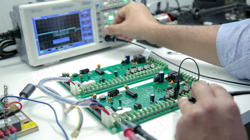 manual electronics soldering and oscilloscope testing photo