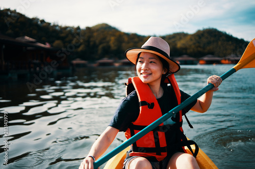Asian girl is kayaking at Kanchanaburi, Thailand. photo