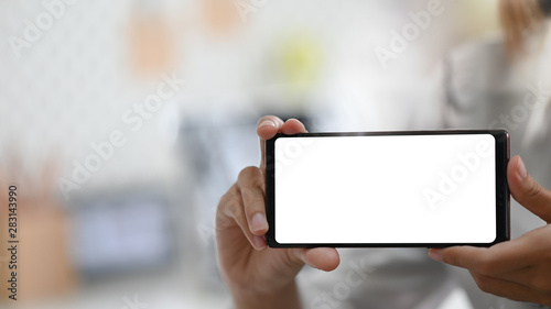 Young woman's showing empty screen of smartphone.