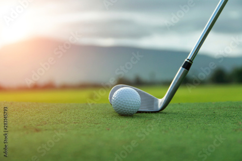 Golf ball and golf club in beautiful golf course at sunset background. Golf ball on green in golf course at Thailand