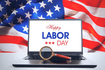 Magnifier and laptop with Happy Labor Day text