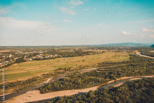 Rural landscape in the low mountains of the Western Carpathians, visible mountain river and fields.