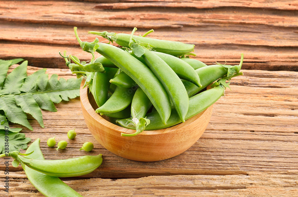 Fresh green peas isolated on a wooden background Fresh green peas isolated on a wooden background