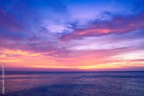 Colorful sunset sky over the ocean with dramatic cloud formation © kudosstudio