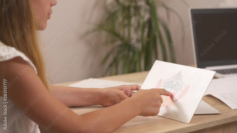 Close-up demonstration video of young girl describing Rorschach inkblot during psychoanalytical session. Examination of person's personality characteristics Close-up demonstration video of young girl describing Rorschach inkblot during psychoanalytical session. Examination of person's personality characteristics